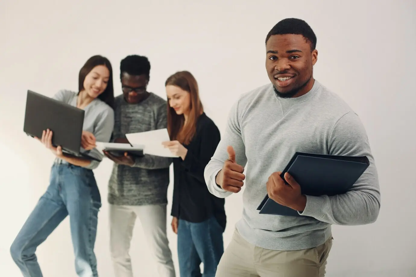 Junge internationale Menschen arbeiten zusammen und nutzen den Laptop.