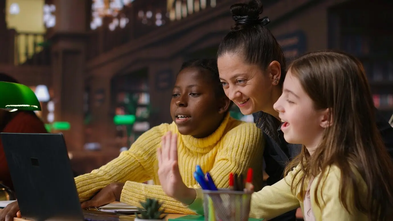 Multiethnische Gelehrte in der Bibliothek, die mit ihrem Mentor am Fernunterricht teilnehmen.